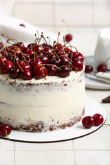 Tasty cherry cake on white tile background