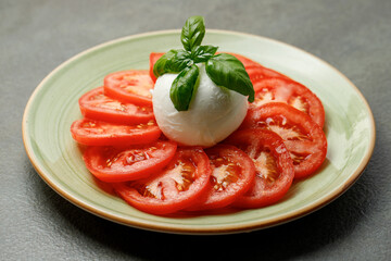 Italian traditional salad Caprese with tomato slices, mozzarella di buffalo and basil 