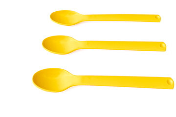Yellow plastic hiking camping cover spoons on a white surface