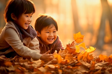 asian kids playing in autumn leaves on a sunny day - Powered by Adobe