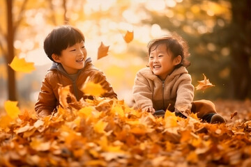 asian kids playing in autumn leaves on a sunny day - 620139132