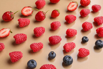 Fresh raspberries, blueberries and strawberries on beige background