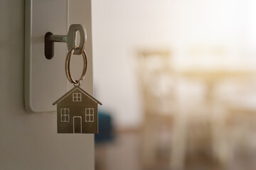 Open door to a new home with key and home shaped keychain. Mortgage, investment, real estate, property and new home concept - 620143553