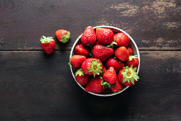 Strawberries in bowl on wooden table, top view copy space. Summer berry fruit harvest - 620144985