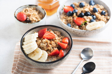 Breakfast oat cereals with banana and strawberries in bowl soaked in almond milk, healthy vegan breakfast meal