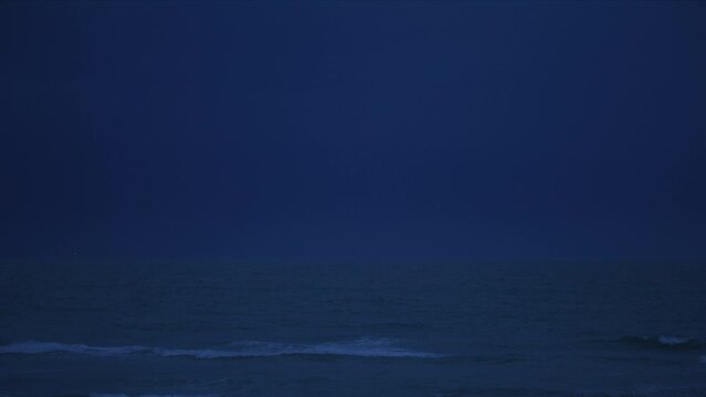 Night lightning thunderstorms at sea striking the ocean 