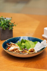 Rolls with duck and vegetables in a tortilla, Peking duck appetizer in a Asian restaurant.