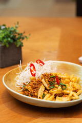 Fried squid with vegetables, chili and spices in a restaurant, Asian cuisine. Vertical orientation, hard light.
