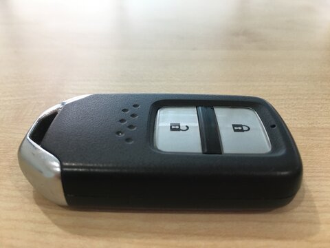 Car key with remote control on the wooden table, closeup of photo