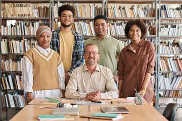 Portrait of migrant students with teacher smiling at camera while learning foreign language in class