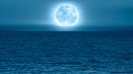 Naklejka na ściany i meble Night sky with blue moon over the calm blue sea 