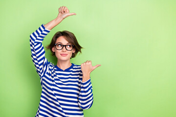 Photo of pretty business lady direct fingers empty space mockup wear spectacles striped shirt...