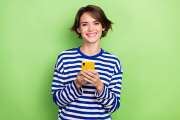 Photo of young optimistic woman blogging hold apple iphone browsing eshopping store purchase advert isolated on green color background