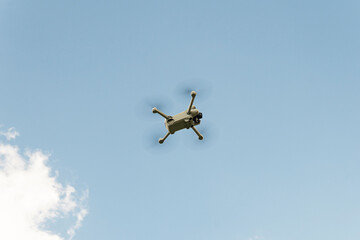 Standing of a small drone in mid-air against strong wind against blue sky