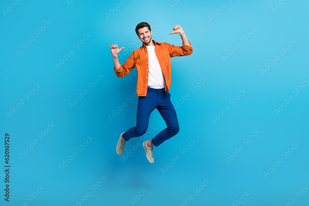 Poster full length portrait of crazy carefree active man jumping point fingers self himself isolated on blu