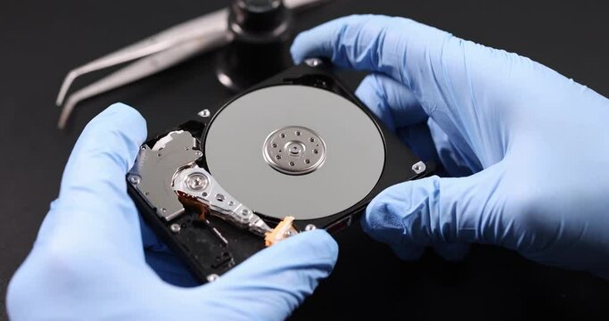 Gloved master holds computer hard drive. Repair and maintenance of computer spare parts concept