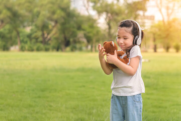 Fototapeta premium Caucasian mix girls play teddy bear doll at outdoors park, Picnic time.