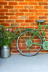 Fototapeta na wymiar Retro style bicycle with flowers as creative decoration in the cozy small street