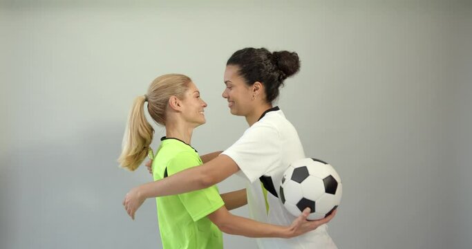 Two female soccer players on white background
