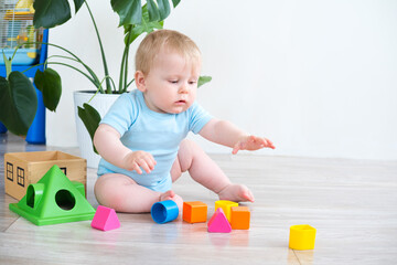 Baby playing with colorful blocks on the floor at home