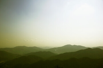 Mountain range in foggy sky background