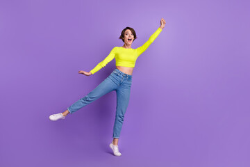 Fototapeta na wymiar Full body photo of cheerful pretty lady dancing hand hold empty space umbrella isolated on violet color background