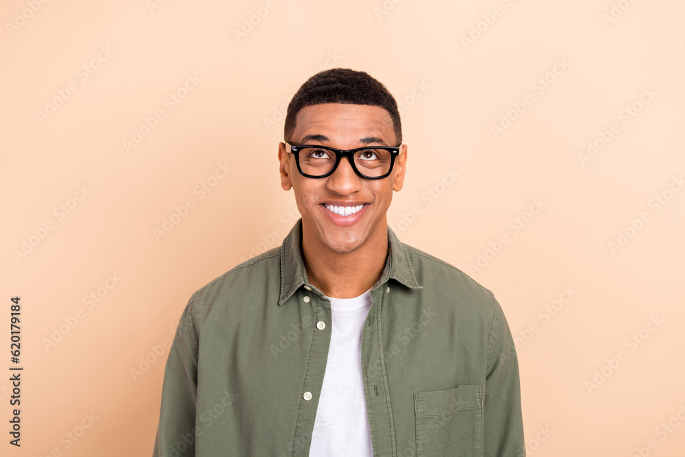 Sticker portrait of nice cheerful guy beaming smile look interested up above empty space isolated on beige c