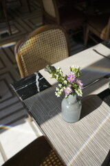 Dining table decorated with daisy ceramic flower vase shined under sun rays