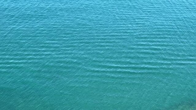 Clear blue water rippled surface aerial view.