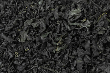 Cuts of dried wakame seaweed close up full frame as background