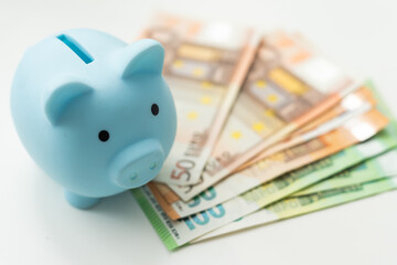 Piggy Bank pink pig made of ceramic is worth 100 dollar and 500 Euro bills. Saving money. Selective focus