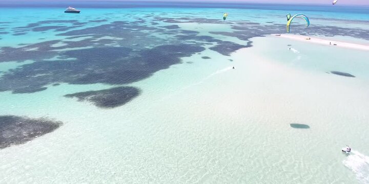 Kitesurfing in Egypt on the ocean from a quadcopter. Surfers freestyle kiteboarding on sea waves