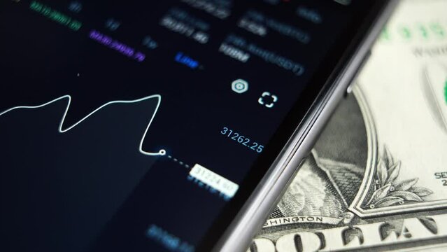 businessman uses a smartphone to check the price of bitcoin on a trading market. macro plan