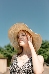 Young woman protecting herself from sun with straw hat