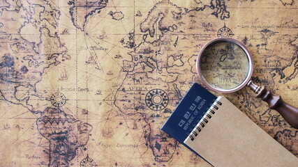 Top view of passport There is a magnifying glass, notebook and world map. travel concept
