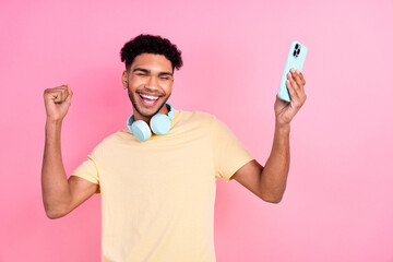 Portrait of satisfied optimistic man with afro hairstyle earrings stubble in headphones hold...