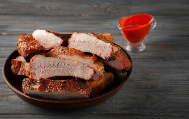 Fried pork ribs served on a plate with tomatoes and ketchup