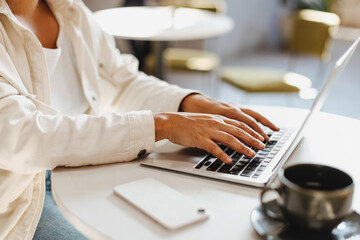 Business woman using a laptop to work in a cafe