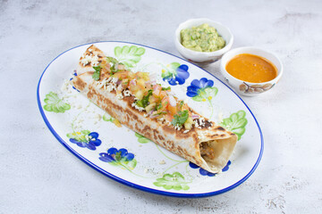 Mexican shredded pork burrito, flour tortilla, refried beans, pico de gallo on a beautiful handcrafted painted plate