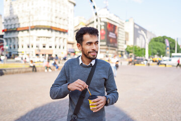 portrait white-collar worker Latin American young adult smiling walking through the streets of...