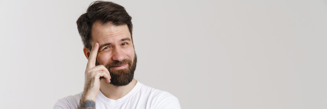 Bearded puzzled man touching his forehead and looking at camera