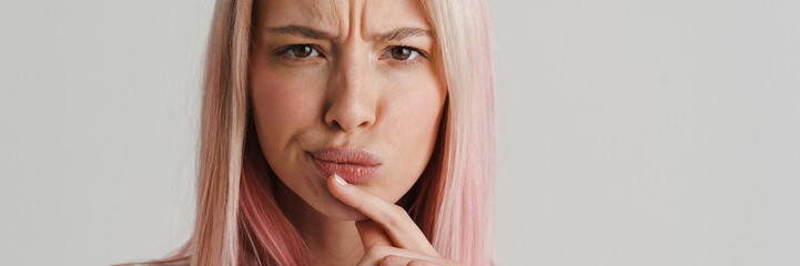 Fototapeta premium Close up of a pensive young woman over gray