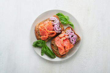 Sandwiches with salted salmon, avocado guacamole, red onions and basil. Smorrebrod. Set of danish open sandwiches. Healthy food, breakfast. Clean eating, dieting, vegan food concept. Top view.