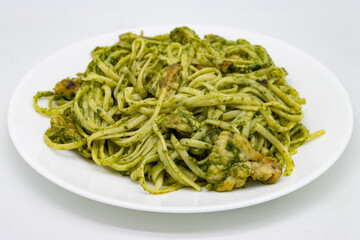 Linguini Pesto Pasta with Chicken on a White Plate