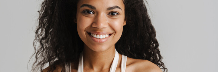 Black young woman in dress smiling and looking at camera