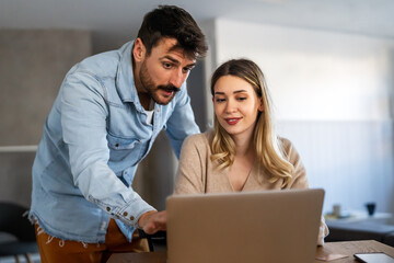 Obraz premium Portrait of success business people working together in home office. Couple teamwork startup concept