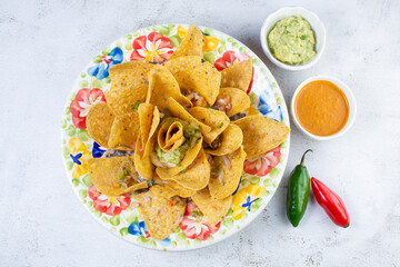 Mexican nachos with guacamole, pico de gallo, accompanied by hot sauce