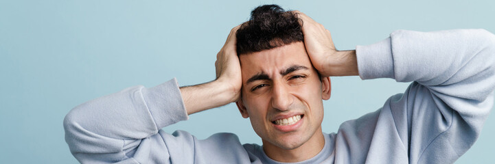 Obraz premium Young middle eastern man with headache holding his head