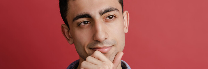 Obraz premium Young middle eastern man smiling and looking aside