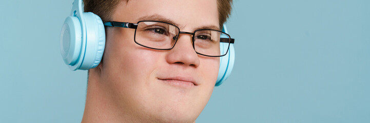 Young man with down syndrome using headphones while listening music
